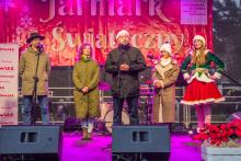 Grupa osób stoi na scenie i składa życzenia mieszkańcom