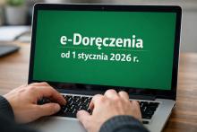 Osoba pisząca na laptopie, z widocznym zbliżeniem na dłonie na klawiaturze i ekran z zielonym tłem oraz napisem: e-Doręczenia od 1 stycznia 2026 r.
