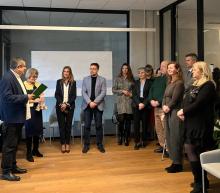 Grupa osób stoi w sali urzędu podczas świątecznego spotkania, w trakcie którego wręczane są podziękowania członkom Rady Seniorów.