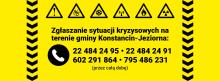 Żółta plansza informacyjna z ikonami zagrożeń i numerami telefonów do całodobowego zgłaszania sytuacji kryzysowych na terenie gminy Konstancin-Jeziorna.