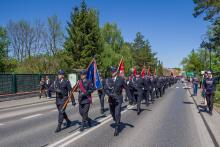 Strażacy ochotnicy maszerują w uroczystej paradzie ulicami Konstancina-Jeziorny podczas obchodów Dnia Strażaka.