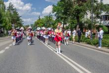 Parada z udziałem orkiestry i mażoretek przemierza ulicę podczas miejskiego święta w Konstancinie-Jeziornie.