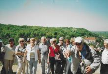 Grupa seniorów pozuje do zdjęcie w krajobrazie wyżynnym