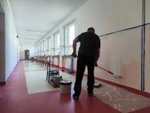 Mężczyzna maluje szkolny korytarz
