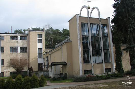 Rozległy budynek, lub kompleks budynków, o zróżnicowanej architekturze, na pierwszym planie po lewej stronie widoczny front kaplicy