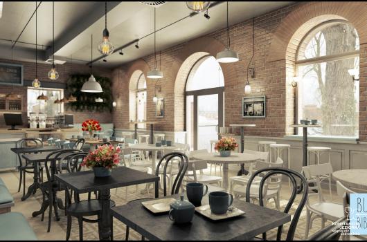 Jasne wnętrze lokalu restauracyjnego, oświetlone przez duże pólkoliste okna po prawej, weanątrz stoliki i krzesła, ściany surowe z cegieł