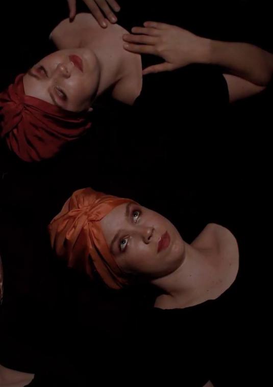 Na czarnym tle pięć popiersi kobiety, wokalistki zespołu Ciepłe Popołudnie, w różnych nakryciach głowy, ułożone w okrąg.