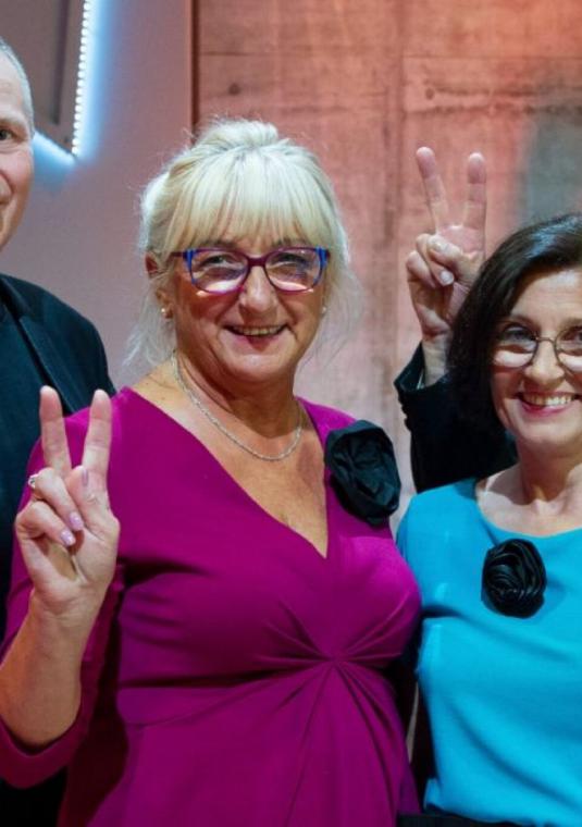 Dwie kobiety i dwóch mężczyzn w wieku senioralnym stoją obok siebie.