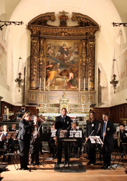 Grafika przedstawia orkiestrę grajacą pod ołtarzem kościoła.