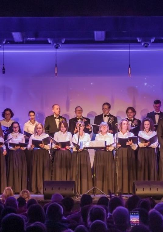 Zespół osób śpiewających w sali