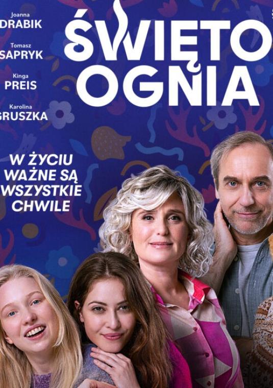 grupka osób uśmiechniętych na tle granatowym z napisami