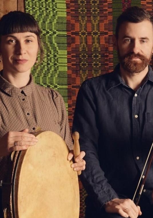 zdjęcie muzyków z kapeli Niwiński trzymających instrumenty: skrzypce i tamburyn