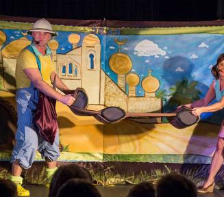 Bajkowa scenografia teatralna, na scenie doje aktorów w bajkowych przebraniach..