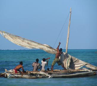 Czworo męzczyzn na niedużej łodzi. W tle widac drugą łódkę. Ocean jest spokojny, a niebo bezchmurne.