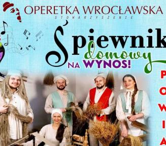 grupa osób ubrana w stroje, z łanami zbóż na błękitnym tle