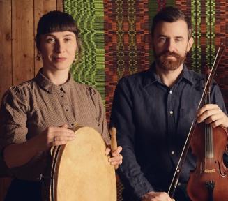 zdjęcie muzyków z kapeli Niwiński trzymających instrumenty: skrzypce i tamburyn