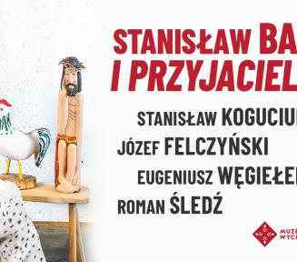 Plakat wystawy „Stanisław Baj i Przyjaciele” w Muzeum Wycinanki. Na zdjęciu widoczne są kolorowe rzeźby ludowe (ptaki, postać Chrystusa) oraz obraz na sztaludze w pracowni artystycznej.
